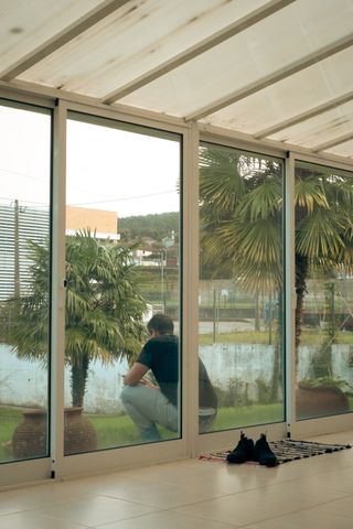 A man viewed sitting outside of a veranda