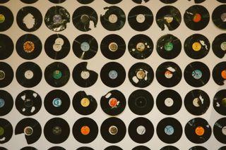A wall covered in vinyl discs in different conditions