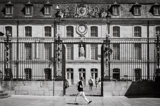 A person walking in front of an old renaissance building