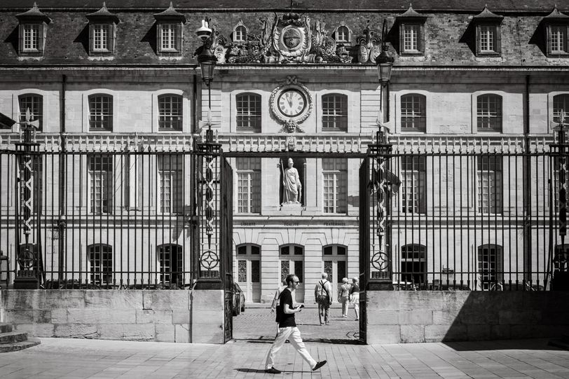 A person walking in front of an old renaissance building