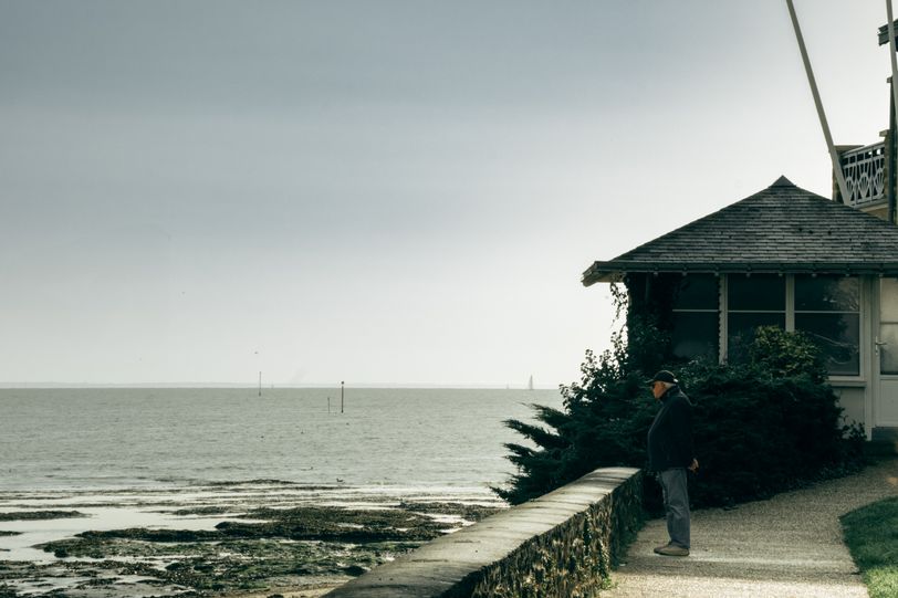 A man on a dock looking at the sea