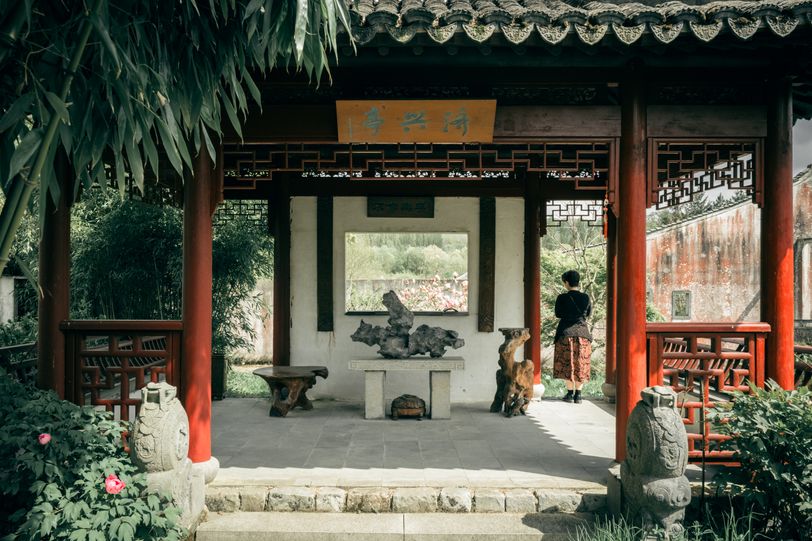 An asian temple-like construction with a person standing inside it
