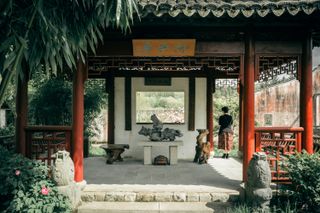An asian temple-like construction with a person standing inside it