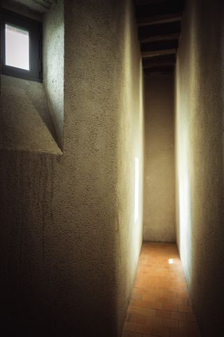 A narrow hallway only enlighted by a small window