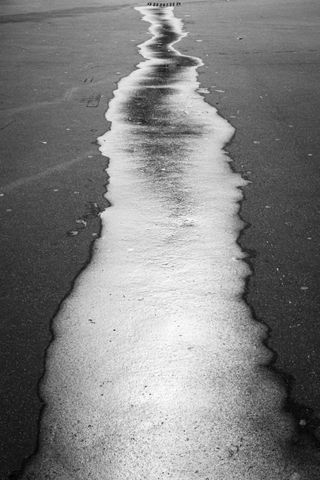 Remains of a wet asphalt before a water drain