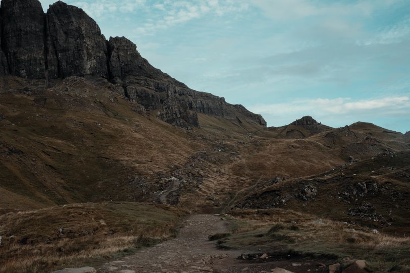 Landscape of a path going up a deserted mountain with a blue sky