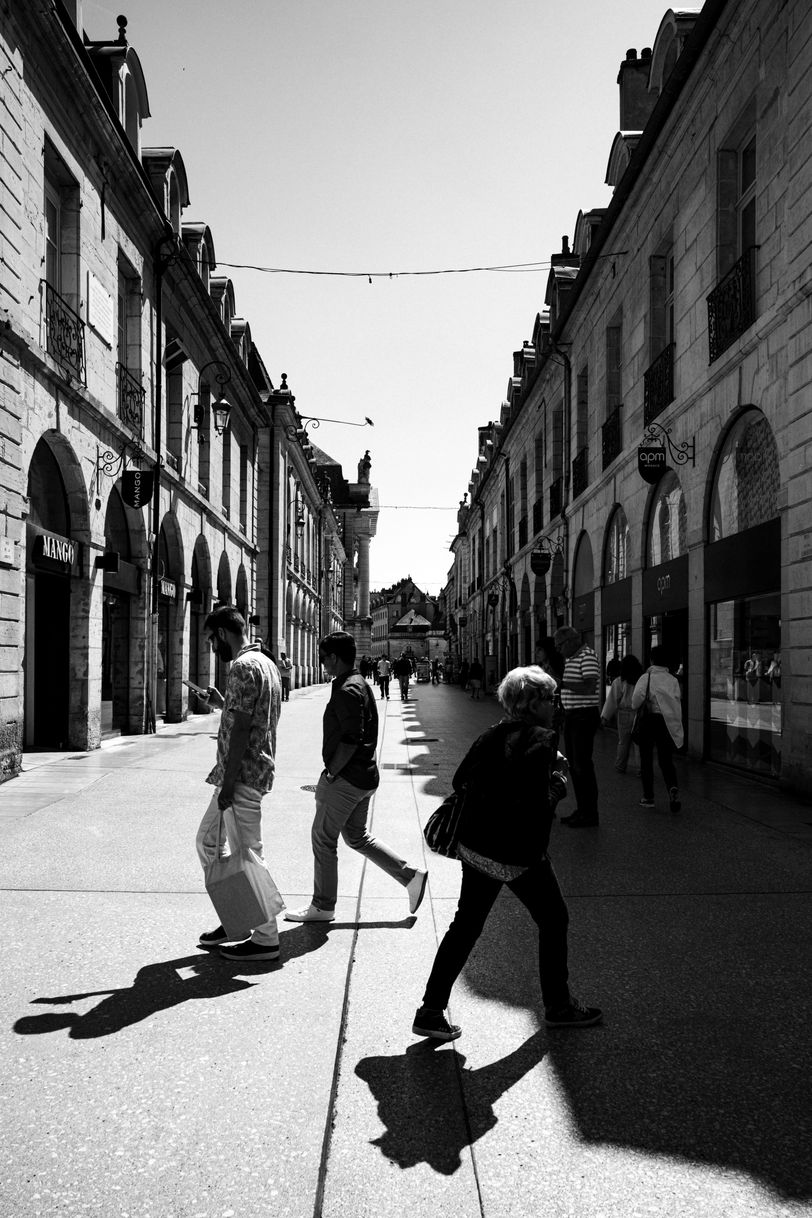 A pedestrian street half in the sun, half in the shadow