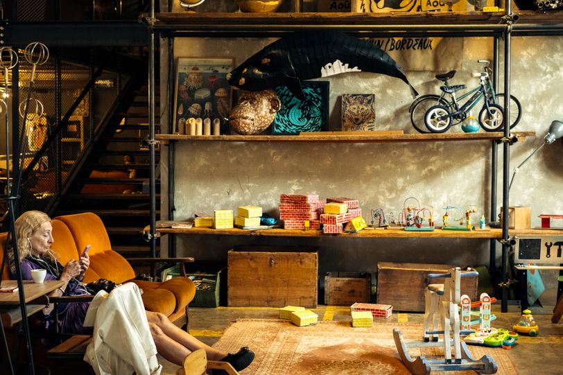 An old lady sitting in a children playroom