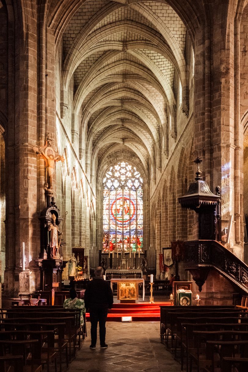 Two people in an empty glowing church facing the altar while praying
