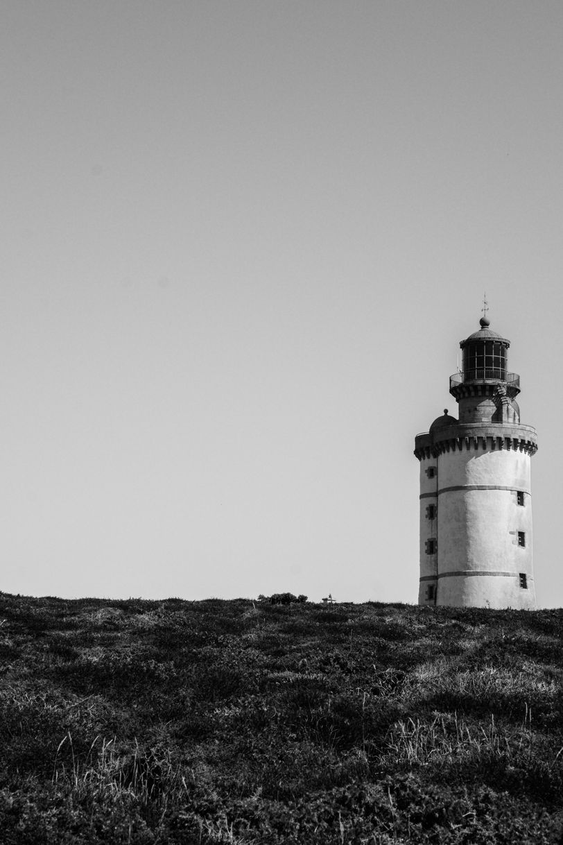 A lighthouse behind a hill