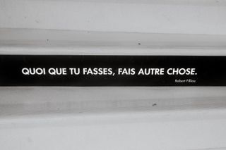 A quote written on stairs saying "whatever you're doing, do something else"