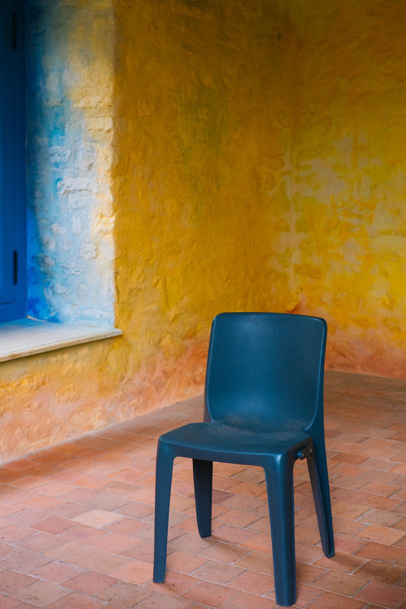 An empty chair in an epmty colored room