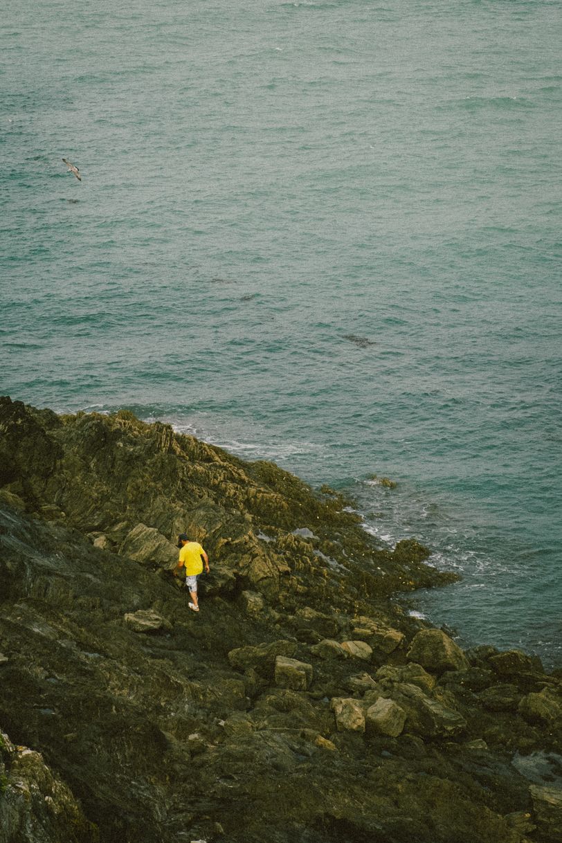 A man with flashy yellow shirt on the coast