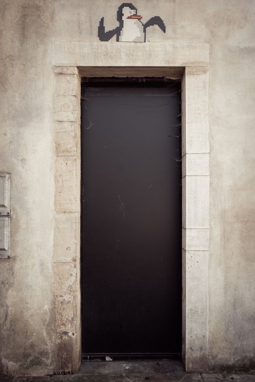 An outside door with a dancing penguin image above