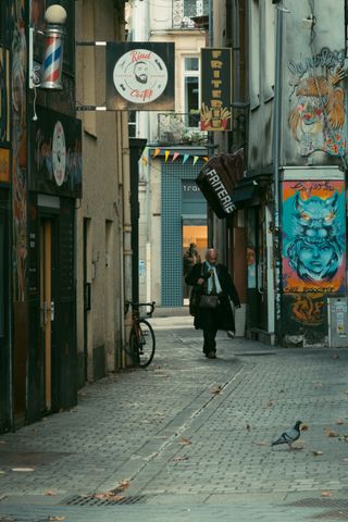 A pensive business man walking in a narrow and empty street