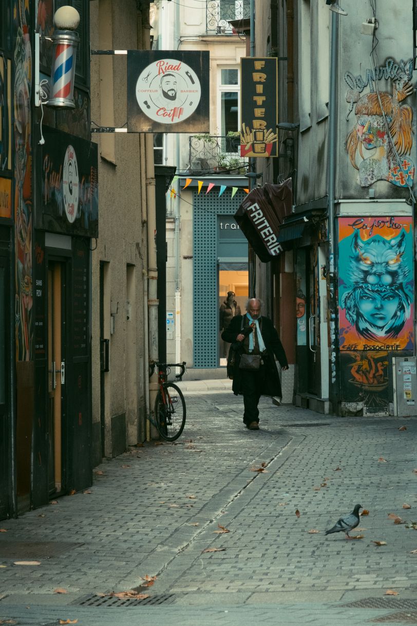 A pensive business man walking in a narrow and empty street