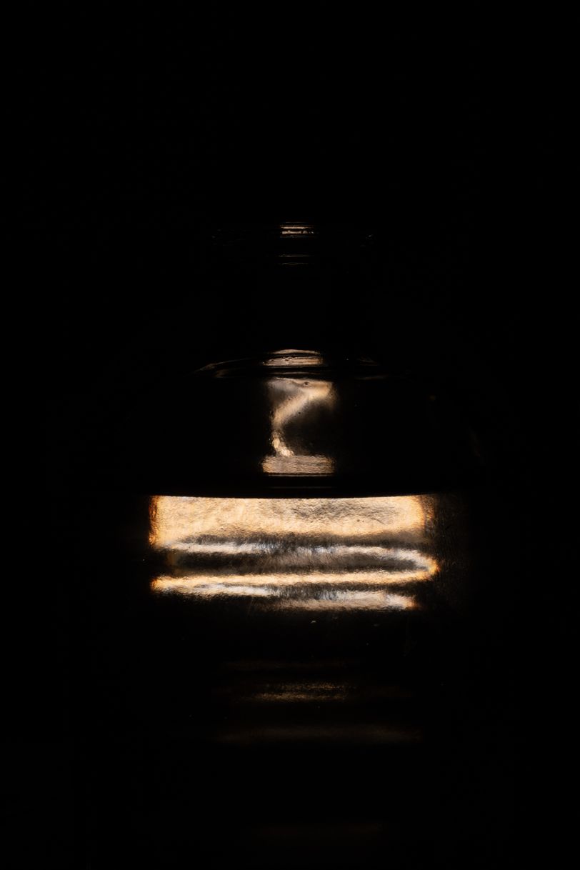 Abstract picture of a lighbulb behind a bottle of water