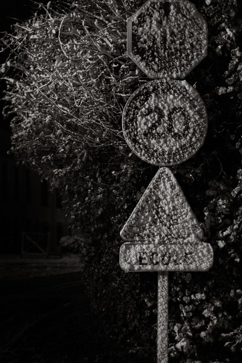 Roadsigns barely readable because of the snow covering them