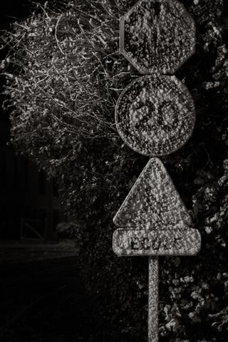 Roadsigns barely readable because of the snow covering them