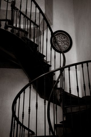 Dark spiral staircase on a light wall