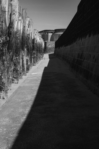 Path between a breakwater and a dock partially in the shadows