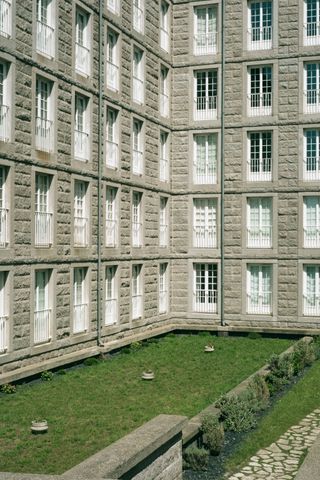 Building with a lot of windows before a sober green field
