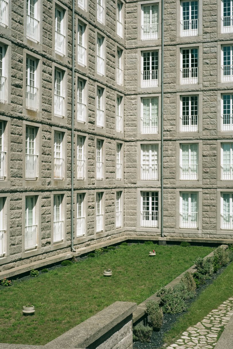 Building with a lot of windows before a sober green field