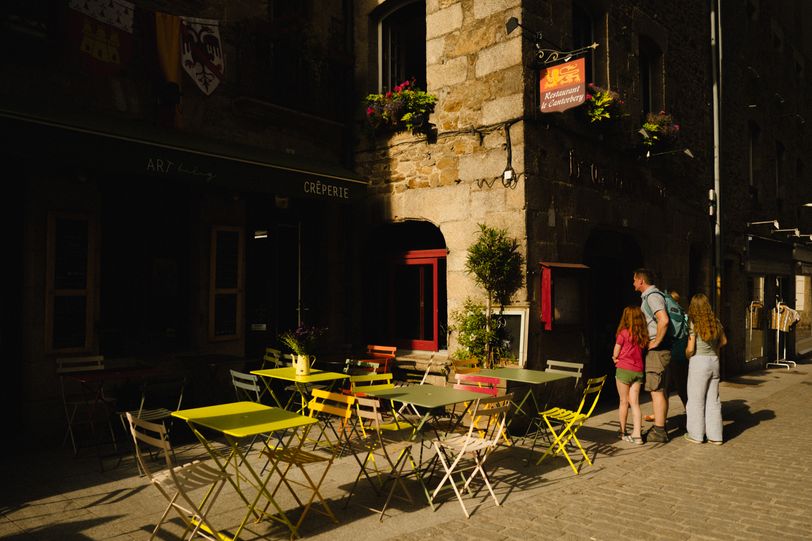 Street partially in the dark because of a low sun and tall buidlings