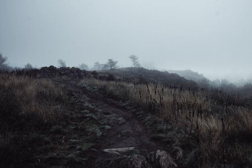 Dimmed hike on a hill on a foggy weather