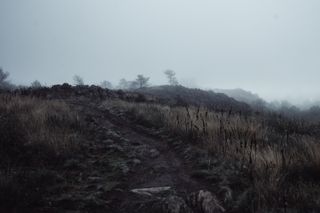 Dimmed hike on a hill on a foggy weather