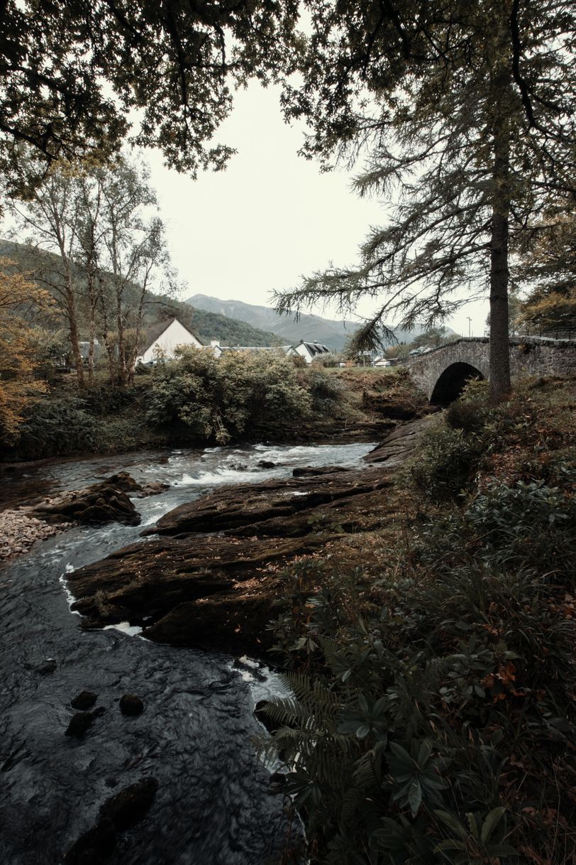 View on a river going under a bridge with houses in a valley on the other side
