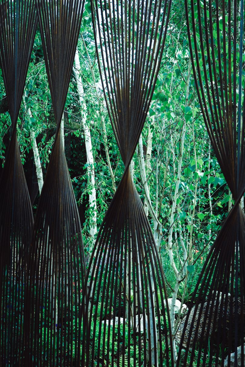 Twisted metal bars before a garden