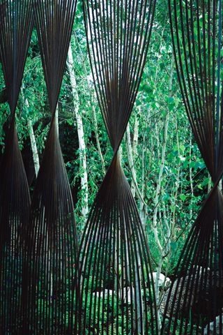 Twisted metal bars before a garden