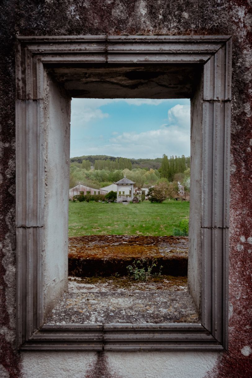 A window's frame showing a bucolic landscape behind