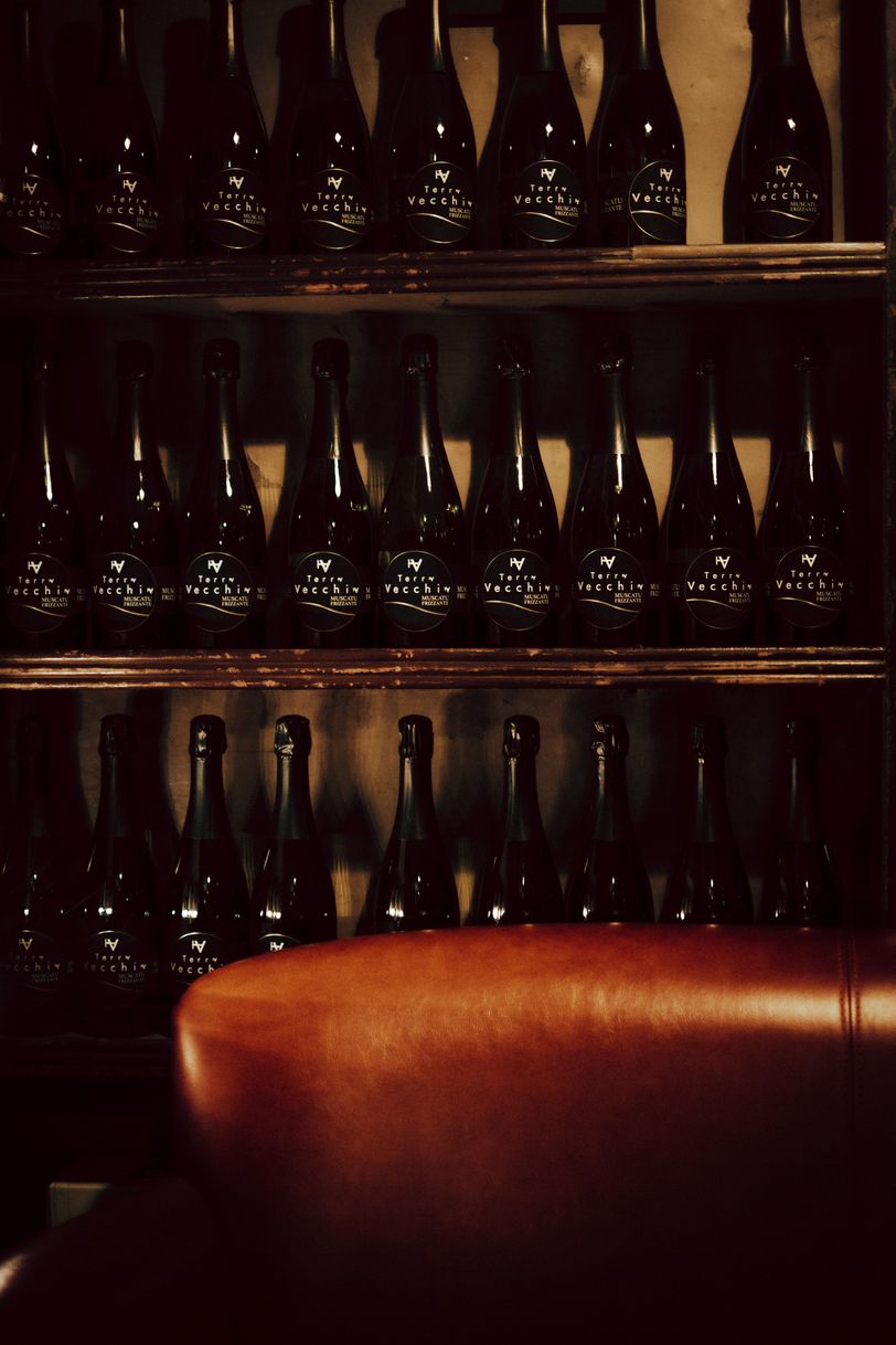 Shelves of wine bottle behind a sofa